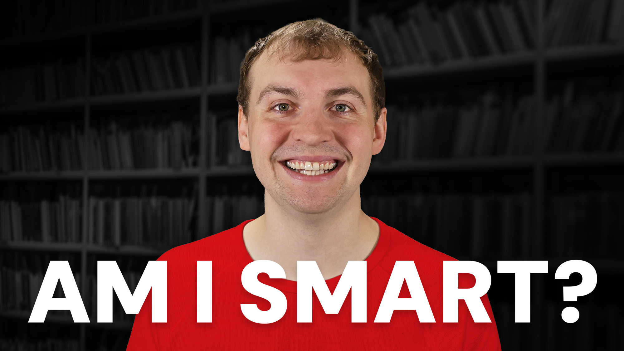 A man with a wide smile, wearing a bright red crew neck shirt, is centered in the frame. Across the bottom, large bold white text asks, "AM I SMART?" The background consists of dark, blurred bookshelves in a library.