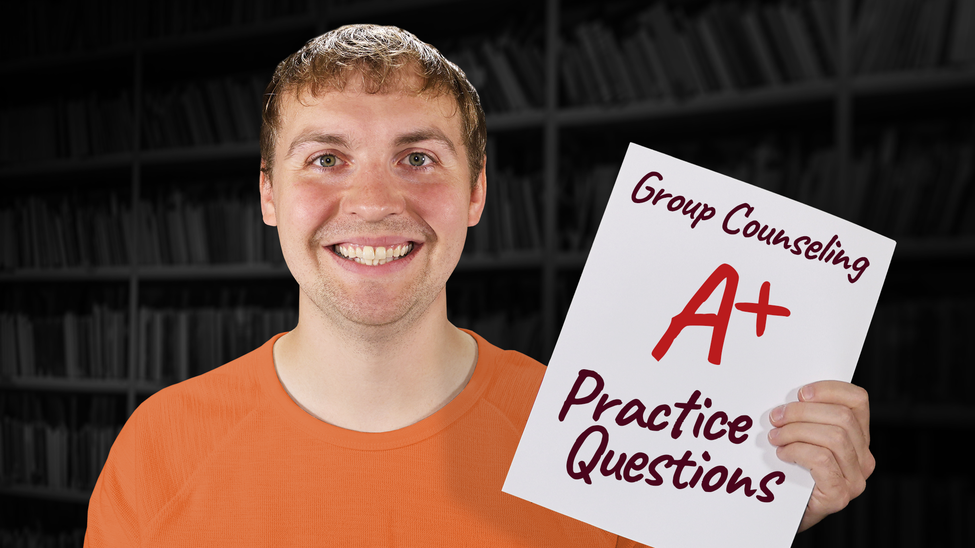 A young man with dark blonde hair and a broad smile, wearing an orange crew neck t-shirt, stands in front of a blurred background of dark bookshelves. He is holding a white paper that features the text "Group Counseling" at the top in dark script, a large "A+" in bright red marker in the center, and "Practice Questions" at the bottom in dark script.